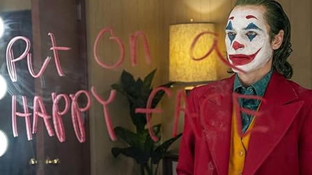Screen capture from Joker, now included in conversations about movies that aged badly, showing Arthur Fleck in clown makeup standing alone under harsh lighting.