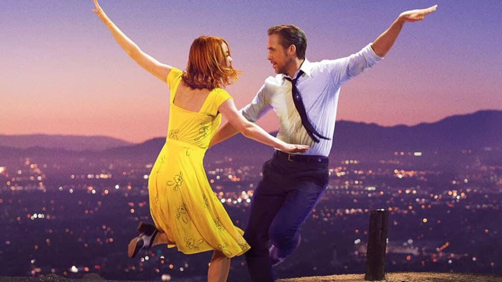 Screen capture from La La Land, now discussed alongside movies that aged badl, showing Mia and Sebastian dancing together against a city backdrop at dusk.