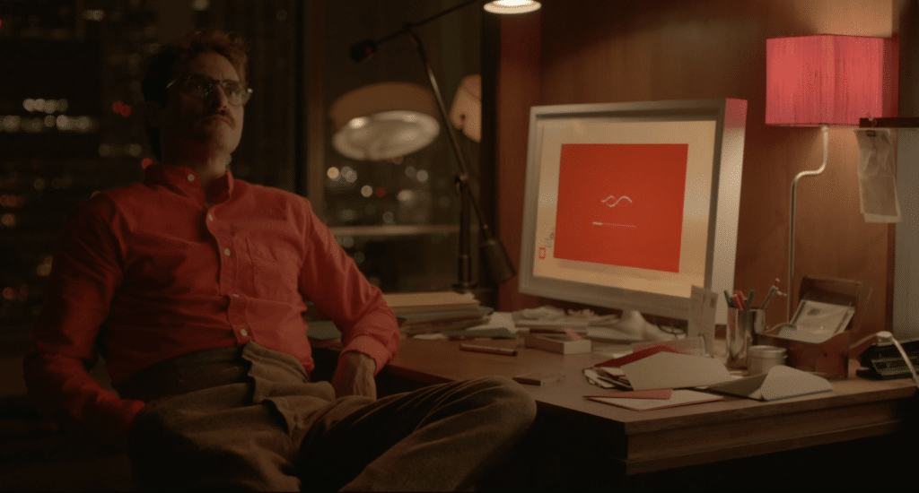 Theodore from Her sitting alone while listening to his AI companion through an earpiece.